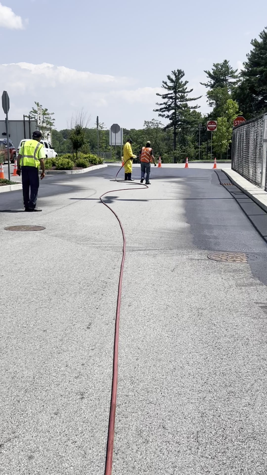 Crew spraying sealcoat on commercial property